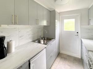 una cucina con mobili bianchi e un lavandino di 5 person holiday home in TENHULT JÖNKÖPING a Hult