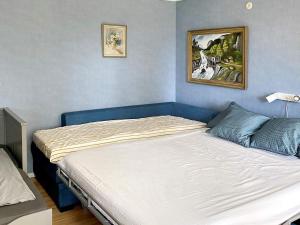 a bed in a bedroom with a blue wall at 5 person holiday home in Tenhult Jönköping in Hult