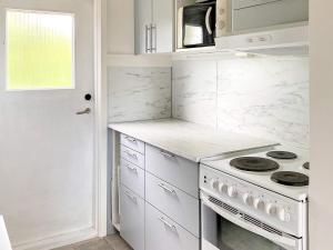 una cucina con ripiani bianchi e forno a piano cottura di 5 person holiday home in TENHULT JÖNKÖPING a Hult