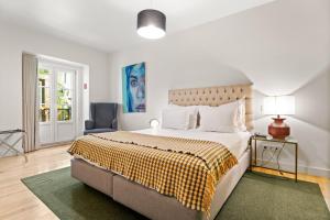 a bedroom with a large bed and a chair at Monte Belvedere Hotel by Shiadu in Lisbon
