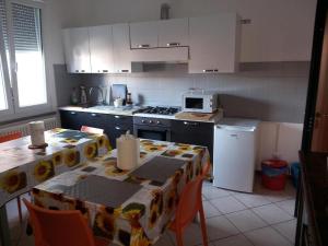 a kitchen with a table with chairs and a kitchen with white cabinets at CAMERE DI ARHET in Parma