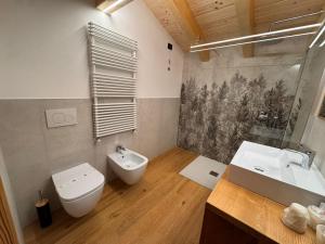 Un baño con inodoro, bidé y lavabo. en Albergo Scoiattolo, en Falcade 95 fotos más