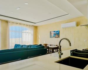 a living room with a blue couch and a table at Danny House in Nadur