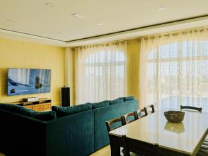 a living room with a blue couch and a table at Danny House in Nadur