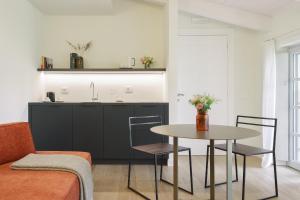 ein Wohnzimmer mit Tisch und Küche in der Unterkunft Cuna Milano in Mailand
