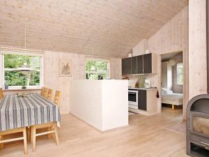 a kitchen and dining room with a table and a stove at 4 star holiday home in Ålbæk in Bunken