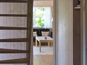 a living room with a table and a couch at 4 star holiday home in Ålbæk in Bunken +21 photos