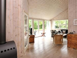 a living room with wood paneled walls and wooden floors at 4 star holiday home in Ålbæk in Bunken
