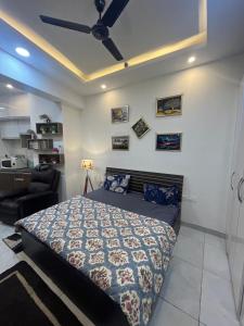 a bedroom with a bed and a ceiling fan at Coco Northeye Mall Studio in Noida