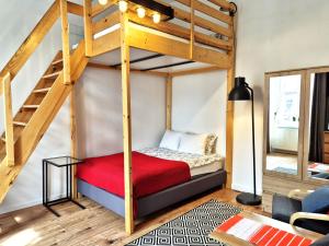 a bedroom with a bunk bed with a red blanket at Apartamenty Stary Rzeszów in Rzeszów