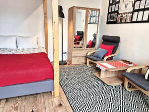 Apartamenty Stary Rzeszów في جيشوف: غرفة نوم بسرير وكرسيين ومرآة