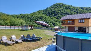 a group of chairs and a swimming pool with a house at Файний будинок in Mizhhirʼʼya
