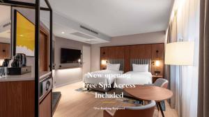 a bedroom with a bed and a table in a room at voco Stockholm - Kista by IHG in Stockholm