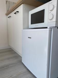 a microwave oven sitting on top of a refrigerator at Apartament 13 z Balkonem, Centrum Grzybowo - Nadmorska 26 in Grzybowo