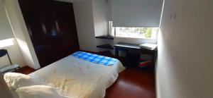 una habitación pequeña con una cama y un escritorio en Colina 804, en Bogotá