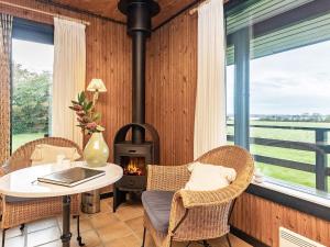 a room with a fireplace and a table and chairs at 8 person holiday home in Svendborg in Svendborg +27 photos