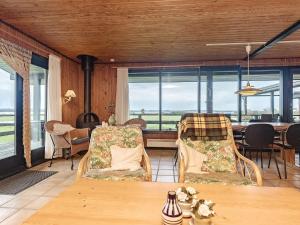 a living room with a table and chairs and windows at 8 person holiday home in Svendborg in Svendborg
