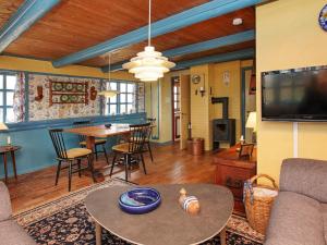 a living room with a table and a tv at Charming Seaside Cottage - By Traum Ferienwohnungen in Fjand Gårde