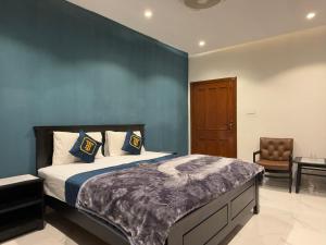 a bedroom with a king sized bed and a chair at Tabash Hotel, Murree in Murree