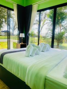 un grande letto con lenzuola bianche e una finestra di Fueng Fah Villa Sea Views a Nakhon Si Thammarat Altre 127 foto