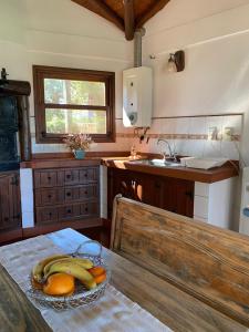 Una cocina con un plato de plátanos y naranjas en una mesa. en Cabañas lodge El Suizo, en Gobernador Virasora 47 fotos más