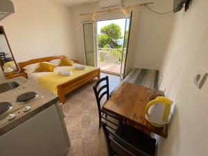 a room with a kitchen and a table and a bed at Apartments San Giorgio in Sućuraj