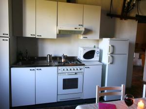 y cocina con fogones blancos y nevera. en Mansion in Magione near Zocco Beach, en Magione