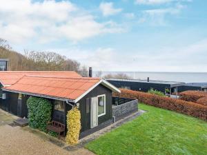 a small house with an orange roof in a yard at 5 person holiday home in Juelsminde-By Traum in Sønderby
