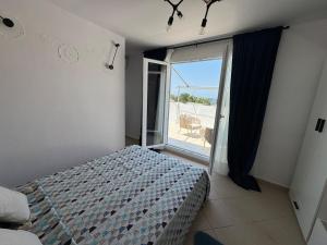a bedroom with a bed and a balcony with a view at Relax INN Sea and Olympus View in Nea Kallikrateia