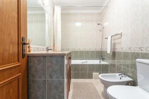 a bathroom with a toilet and a sink and a tub at Blife Vitorya private apartment in Faro