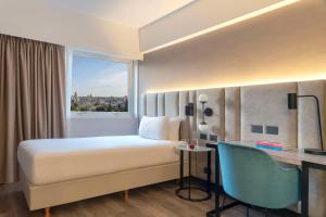 a bedroom with a bed and a desk and a window at NH Santiago del Estero in Santiago del Estero +29 photos