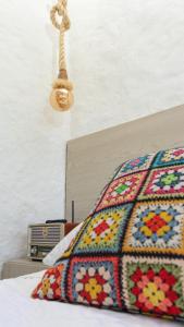 a bed with a colorful blanket on top of it at La Morena - Hospédate en una finca cafetera tradicional in Pereira