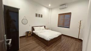 a small bedroom with a bed and a window at D'Igel Boutique in Da Nang