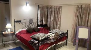 a bedroom with a bed with red sheets and pillows at Taj Waves Villa - Pink Barbie Themed Pool View Room in Agra