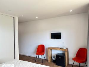 two red chairs and a table in a bedroom at Paços de Douro - Bedroom 5 Relaxation & Space in Romariz
