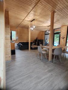 a dining room and living room with a table and chairs at Escape Remeti - Aframe by the River in Remeţi