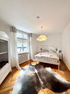 a bedroom with a white bed and a large window at VIKARO Apartment in Monschau