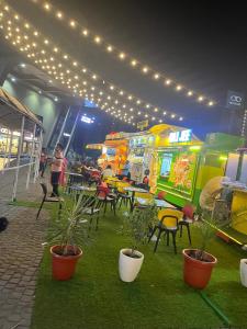 a food court with tables and chairs and lights at Coco Northeye Mall Studio in Noida +11 photos