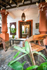 a living room with a bench and a table at Jardin d'Ulysse & Hard Rock in Morjim
