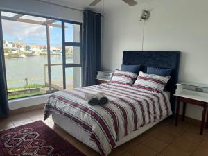 a bedroom with a bed with a view of the water at Skoenlapper holiday home in Velddrif +8 photos