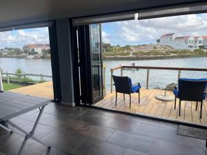 a balcony with two chairs and a view of the water at Skoenlapper holiday home in Velddrif