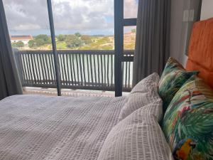 a bedroom with a bed and a view of a balcony at Skoenlapper holiday home in Velddrif