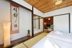 a bedroom with two beds and a desk at Mensore Houese in Naha