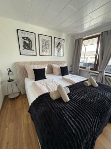 a bedroom with a large bed with two towels on it at RheinLoft Apartment - Balkon & Parkplatz "optional" am Deutschen Eck in Koblenz