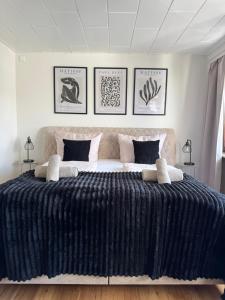 a bedroom with a large bed with black and white sheets at RheinLoft Apartment - Balkon & Parkplatz "optional" am Deutschen Eck in Koblenz