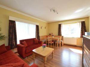 Una sala de estar con un sofá rojo y una mesa. en Apartment in St Michael near Ski Slopes, en Sankt Michael im Lungau
