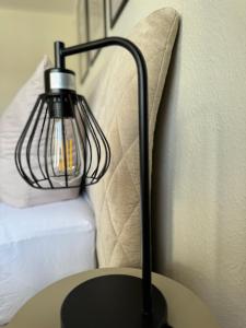 a black lamp sitting on a table next to a bed at RheinLoft Apartment - Balkon & Parkplatz "optional" am Deutschen Eck in Koblenz +21 photos