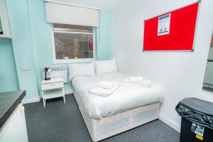 a small room with a bed and a window at Lovely Modern Central Coventry Budget Studio in Coventry +28 photos