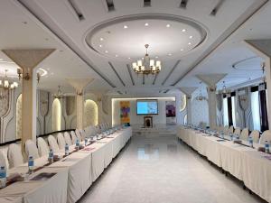 a large banquet hall with white tables and chairs at Herat Star Hotel in Herāt