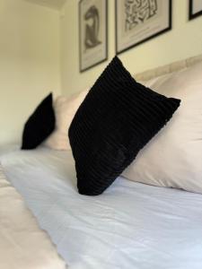 a black pillow sitting on top of a bed at RheinLoft Apartment - Balkon & Parkplatz "optional" am Deutschen Eck in Koblenz